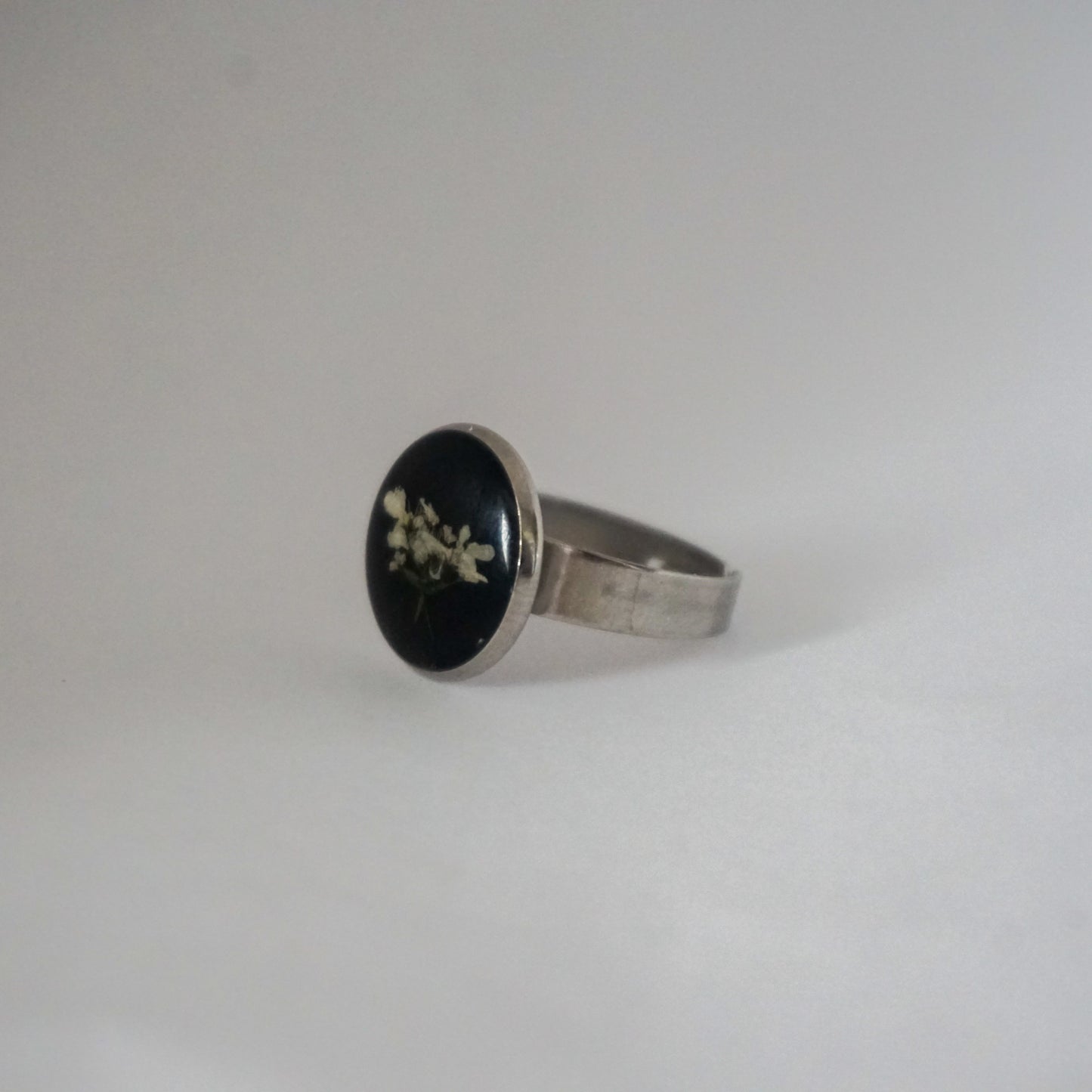 Anillo ajustable flor del cilantro fondo negro